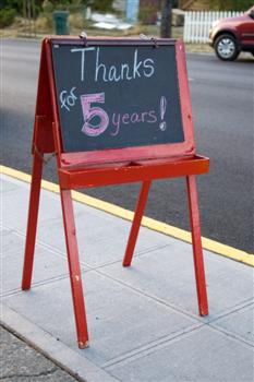 A sign outside Casa d'Italia indicating it's their 5 year anniversary