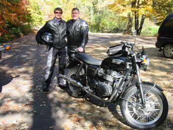 A picture of Karen with her man Perry, all decked out in black leather standing next to Perry's Triumph motorcycle