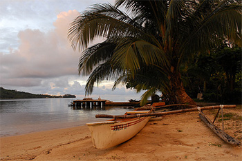 Photograph of a boat on the shore at sunset