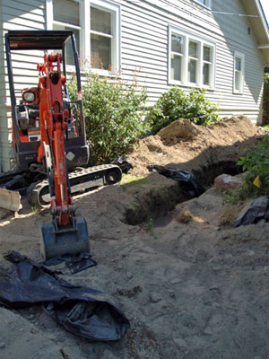 Photo of the sewer trench and mini excavating machine